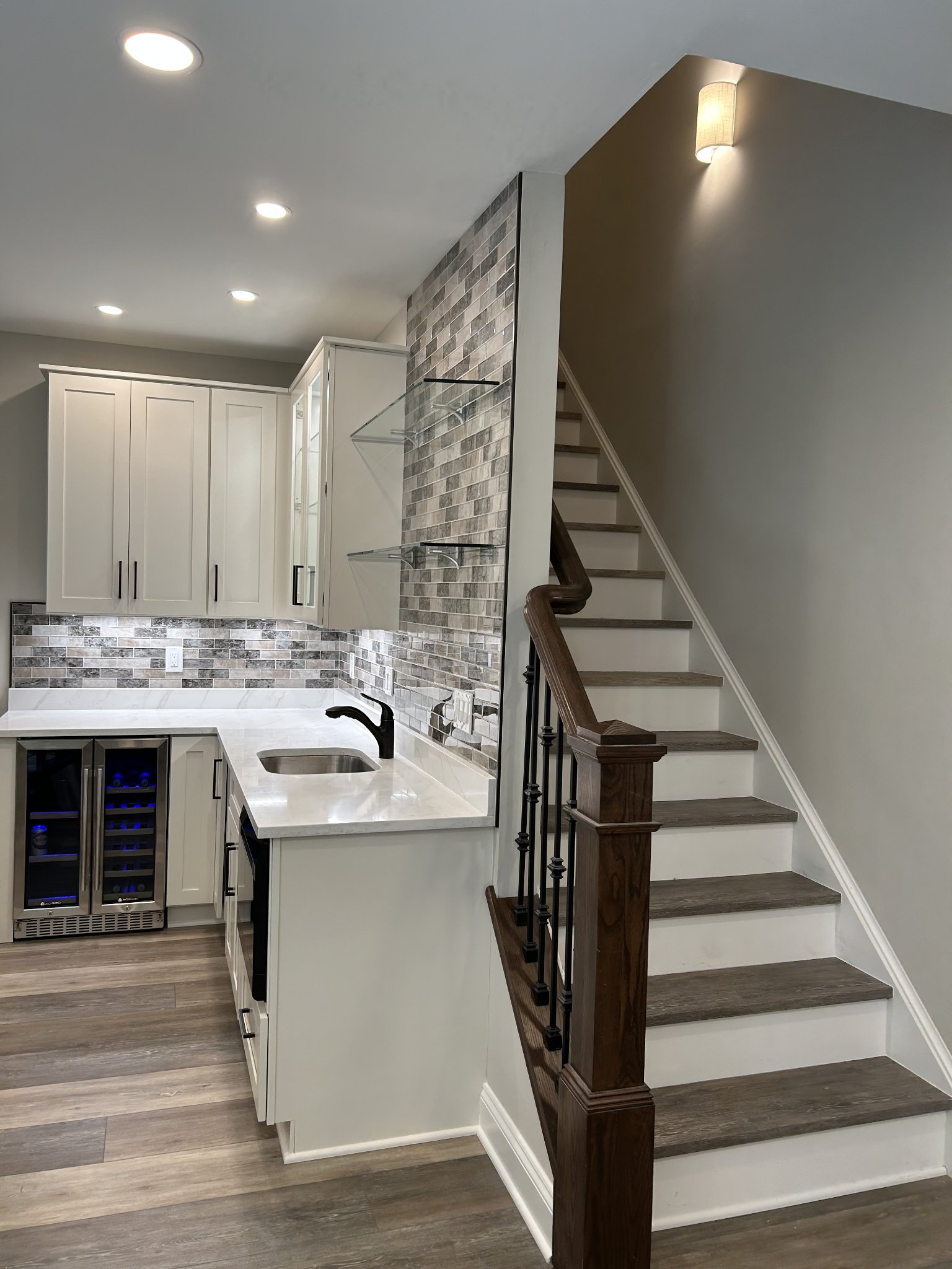 Basement kitchenette with bar area and tile backsplash