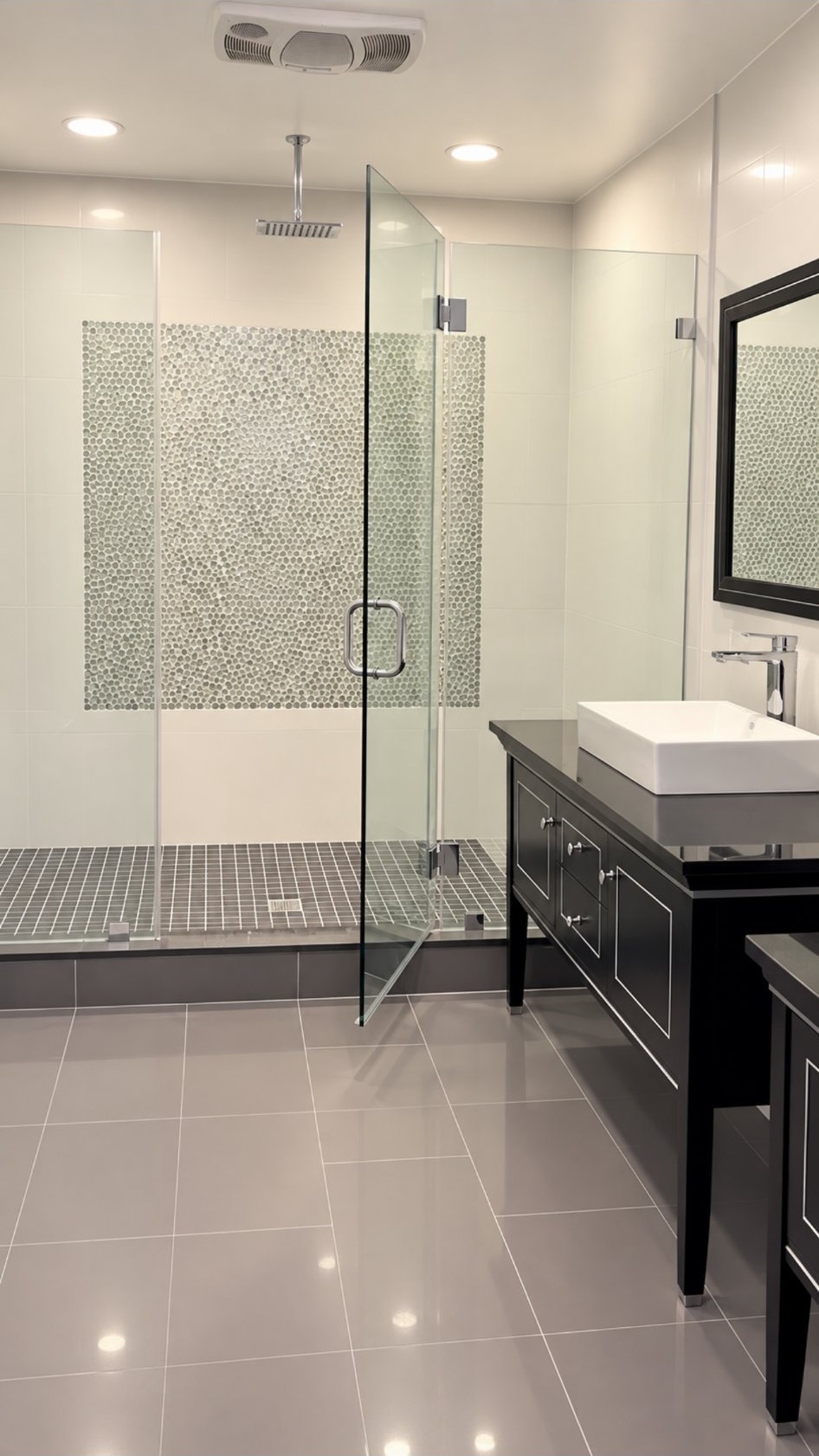 Bathroom with gray tile, glass shower enclosure and vessel sink vanity