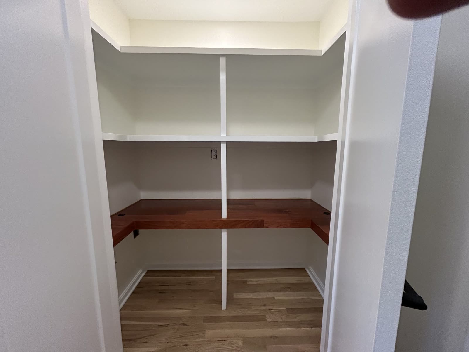 Custom closet with built-in shelving and wood work surface