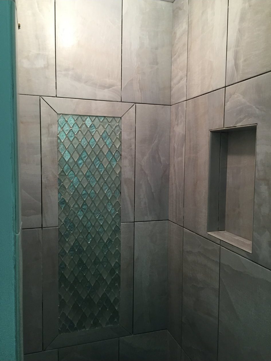 Shower with gray tile and teal mosaic accent strip